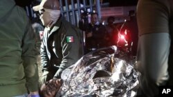 پیرامیڈیکس ایک تارک وطن کو لے جا رہے ہیں جو منگل، 28 مارچ 2023، میکسیکو کے سیوڈاڈ جواریز میں امیگریشن حراستی مرکز میں آتشزدگی میں زخمی ہو گیا تھا۔ اے پی فوٹو