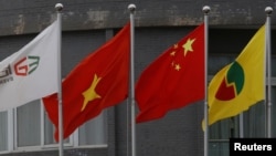 Quốc kỳ của Việt Nam và Trung Quốc treo phía trước một công ty nhựa của Trung Quốc ở tỉnh Bắc Giang, Việt Nam (ảnh tư liệu, 12/8/2017).