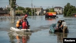 Lực lượng cứu hộ sơ tán cư dân địa phương khỏi khu vực bị ngập lụt sau khi đập Nova Kakhovka bị vỡ, giữa bối cảnh Nga tấn công Ukraine, ở Kherson, Ukraine, vào ngày 7 tháng 6 năm 2023.