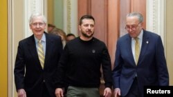 Lãnh đạo Khối Đa số Thượng viện Mỹ Chuck Schumer (phải) và lãnh đạo khối Thiểu số Mitch McConnell (trái) đi cùng Tổng thống Ukraine Volodymyr Zelenskiy khi ông đến thăm Washington, ngày 12/12/2023, để vận động thêm viện trợ.