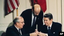 Tổng thống Mỹ Ronald Reagan (phải) và nhà lãnh đạo Liên Xô Mikhail Gorbachev, trao đổi bút tại buổi lễ ký Hiệp ước Lực lượng Hạt nhân Tầm trung INF tại Tòa Bạch Ốc ngày 8/12/1987. 