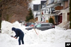 Một người dọn tuyết phía trước đường lái xe của mình vài ngày sau khi một cơn bão mùa đông quét qua phía tây bang New York, ngày 29 tháng 12 năm 2022, ở Buffalo, New York.