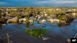 Sau nhiều ngày mưa, nước lũ bao vây nhà và xe cộ trong cộng đồng Planada của Quận Merced, bang California, ngày 10 tháng 1 năm 2023.