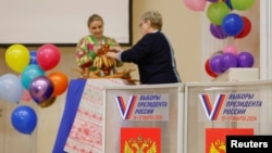 Thành viên của ủy ban bầu cử địa phương đang trang trí tại một điểm bỏ phiếu bầu cử tổng thống ở Vidnoye, Moscow, Nga, ngày 15/3/2024.