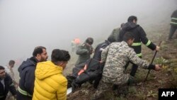 Arama ve kurtarma ekipleri, İran'ın kuzeybatısında kazanın olduğu alanda sis kaplı dağlık bölgeden hayatını kaybedenlerin cesetlerini çıkardı.