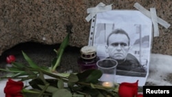 Hoa được đặt cạnh bức chân dung của thủ lĩnh đối lập Nga Alexei Navalny tại tượng đài các nạn nhân của đàn áp chính trị sau cái chết được loan báo của ông, tại Saint Petersburg, Nga, ngày 16/2/2024.