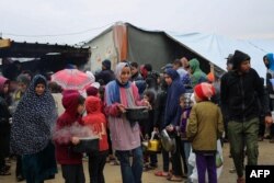رفح میں ایک عارضی خیمہ بستی میں بے گھر فلسطینی خوراک کے راشن وصول کر رہے ہیں ، فوٹو اے ایف پی ، 2 فروری 2024