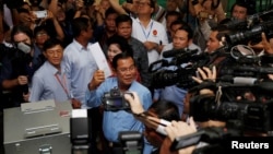 Thủ tướng Campuchia và Chủ tịch Đảng Nhân dân Campuchia Hun Sen với lá phiếu bầu tại một trạm bầu cử ở Takhmao, tỉnh Kandal, hôm 29/7. Các lãnh đạo Việt Nam đã gửi lời chúc mừng "thắng lợi" của cuộc bầu cử mà đảng của ông Hun Sen tuyên bố chiến thắng.