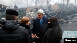 Ngoại trưởng Mỹ John Kerry đứng cạnh các chướng ngại vật tại nơi tưởng niệm những người biểu tình đã thiệt mạng tại Kiev, Ukraina, ngày 4/3/2014.