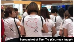 Du khách Trung Quốc mặc áo thun có hình đường lưỡi bò khi vào phi trường Cam Ranh. Báo Tuổi Trẻ cho dấu gạch chéo trên bản đồ này. (screenshot of Tuoi Tre website)