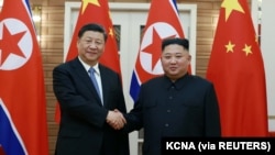 Chủ tịch Trung Quốc Tập Cận Bình, trái, bắt tay nhà lãnh đạo Triều Tiên Kim Jong Un tại Bình Nhưỡng. (Ảnh do Thông tấn xã Trung Ương Triều Tiên KCNA công bố ngày 21/6/2019.) 