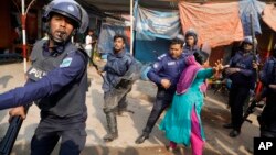 بنگلہ دیش میں گارمنٹ فیکٹری میں کام کرنے والی ایک کارکن کی اجرتوں میں اضافے کے لیے مظاہروں کے درمیان پولیس سے جھڑپ۔