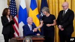 Tổng thống Joe Biden bắt tay Karin Olofsdotter, đại sứ Thụy Điển tại Mỹ, sau khi ký Văn bản phê chuẩn Nghị định thư gia nhập Hiệp ước Bắc Đại Tây Dương cho Vương quốc Thụy Điển tại Phòng Đông của Nhà Trắng ở Washington, ngày 9 tháng 8 năm 2022.