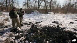 Binh sĩ Ukraine quan sát địa điểm một rốc-kết rơi gần vị trí cùa họ tại Popasna, vùng Luhansk, đông Ukrsine, ngày 14/2/ 2022.