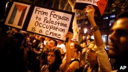  فلسطینیوں کی حمایت میں کی جانے والی ایک ریلی کے مظاہرین فرگوسن میں مائیکل براؤن کی پولیس کی گولی سے ہلاکت کے خلاف بھی احتجاج کر رہے ہیں۔ انہوں نے ایسے بینرز اٹحا رکھے ہیں جن پر لکھا ہے،"فرگوسن سے فلسطین تک، قبضہ ایک جرم ہے۔"