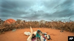 Một phụ nữ Somali và con đang chờ được phân phối chỗ ở tại một trại dành cho những người di tản vì hạn hán tại vùng ngoại ô Dollow, Somalia, ngày 20/9/2022.