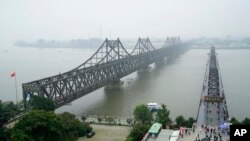 Cầu Hữu nghị Trung-Triều (trái) nối thành phố Đan Đông của Trung Quốc và thành phố Sinuiju của Triều Tiên.